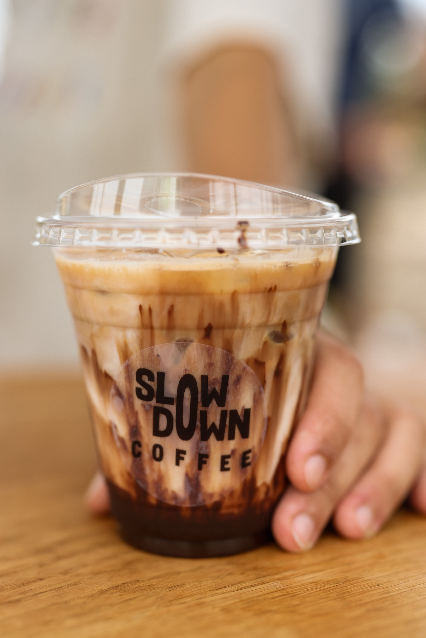 An iced latte in a Slow Down Coffee cup